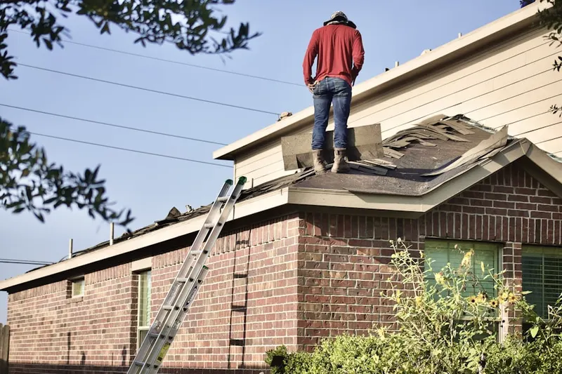 Professional roofer working on a residential roof in Whitford